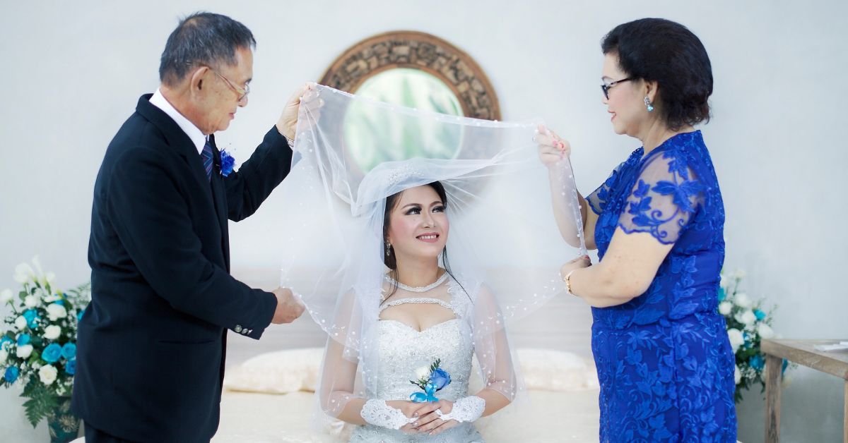bride with her parents holding her wedding veil