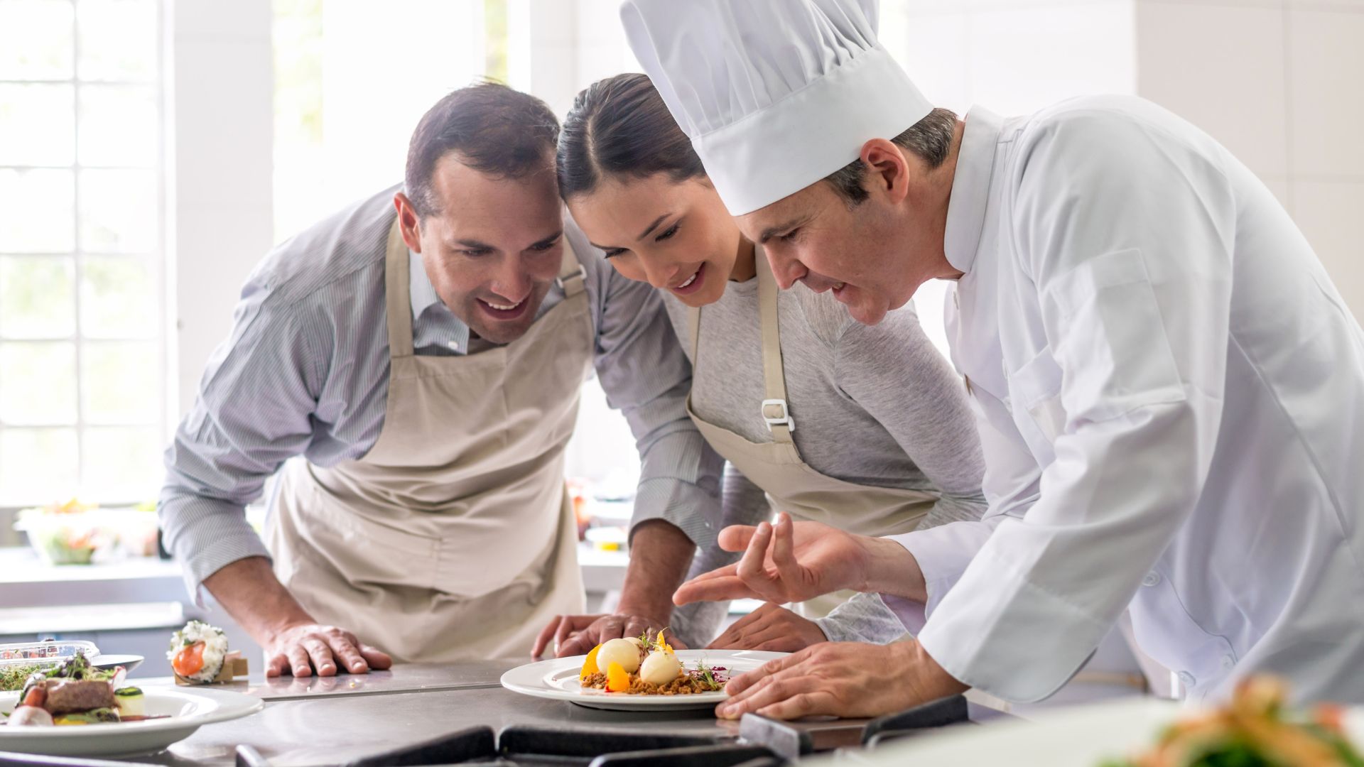 couple learning how to cook with a chef